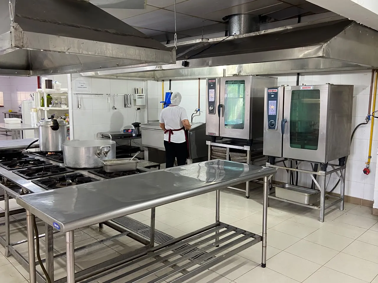 Visão geral da cozinha industrial da Dom Rubi em Suzano, com fornos combinados Rational e bancadas de inox